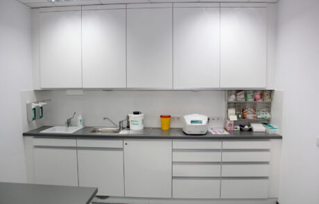 Arbeitszeile für die Sterilgutaufbereitung mit Edelstahlbecken und geräumigen Hochschränken